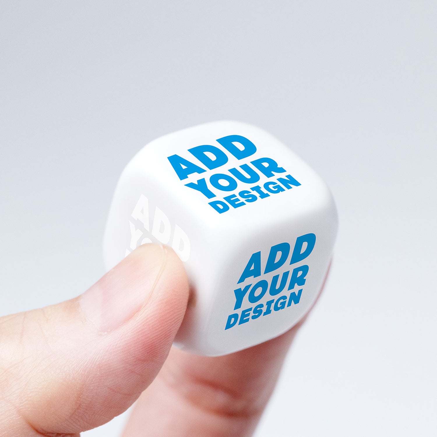 Close-up van een hand die een gepersonaliseerde witte dobbelsteen vasthoudt met zes bedrukte zijden, volledig naar wens aan te passen